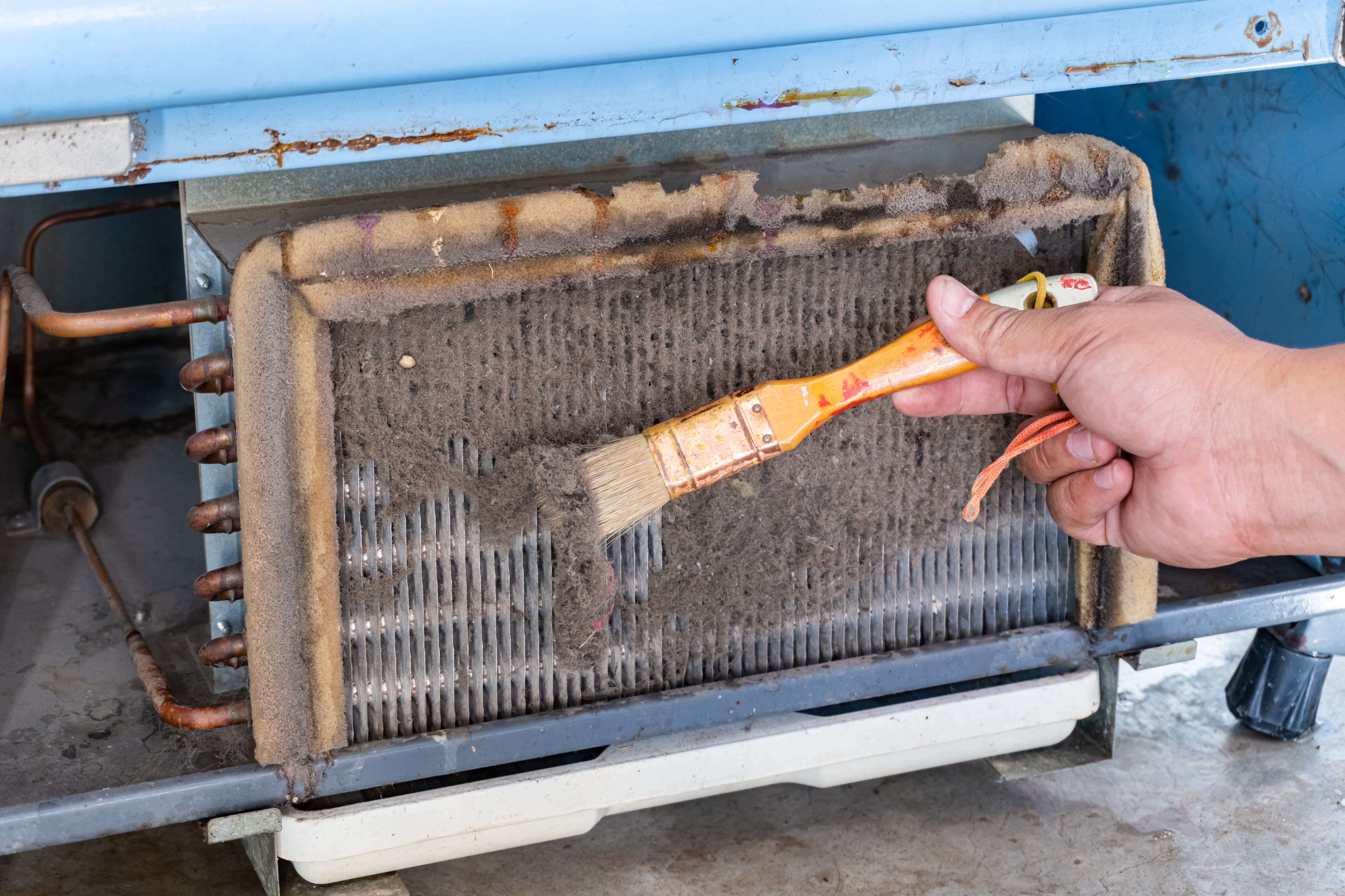 A technician wearing gloves and taking notes during a boiler inspection