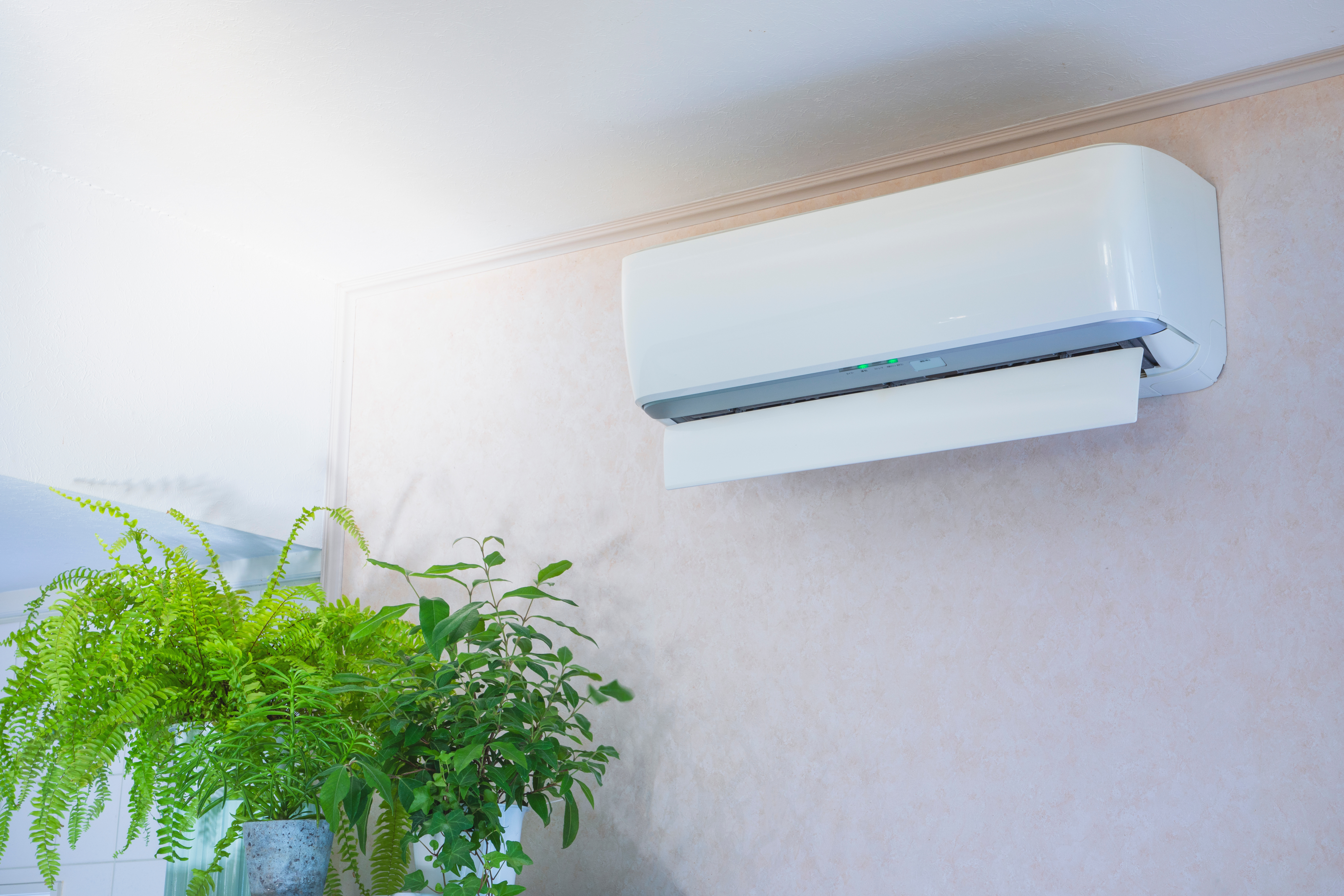 Wall-mounted split air conditioner in a modern interior, actively cooling the room with fresh airflow.
